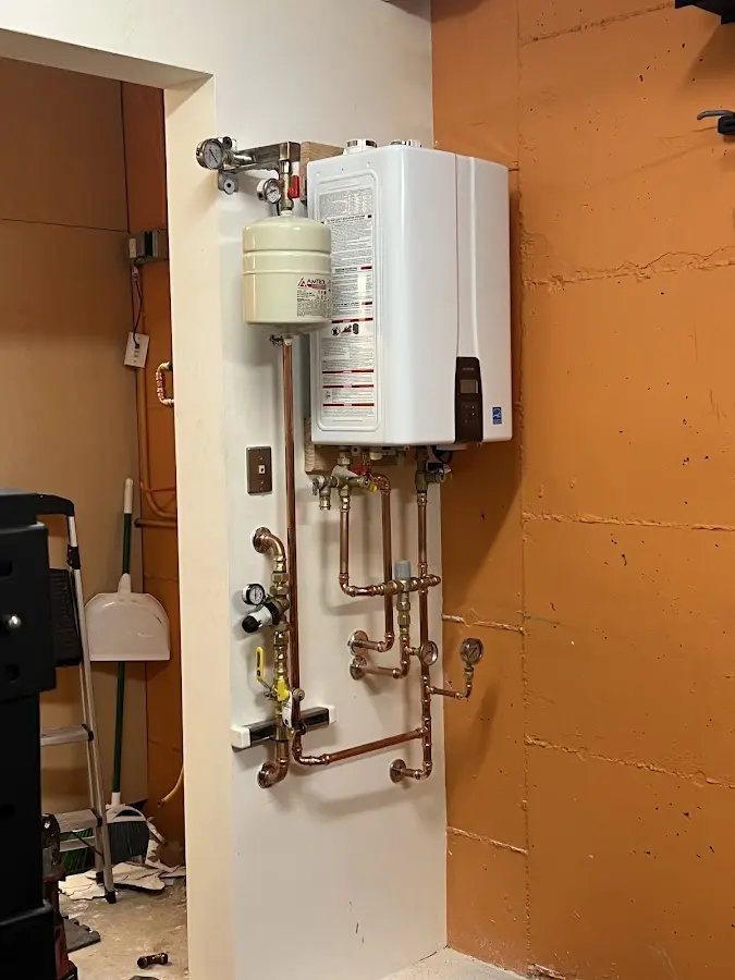 Plumbing technician inspecting water heater connections in Nuevo
